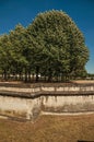 Trees and wall that forms part of the palaceÃ¢â¬â¢s moat of Les Invalides in a sunny day at Paris. Royalty Free Stock Photo